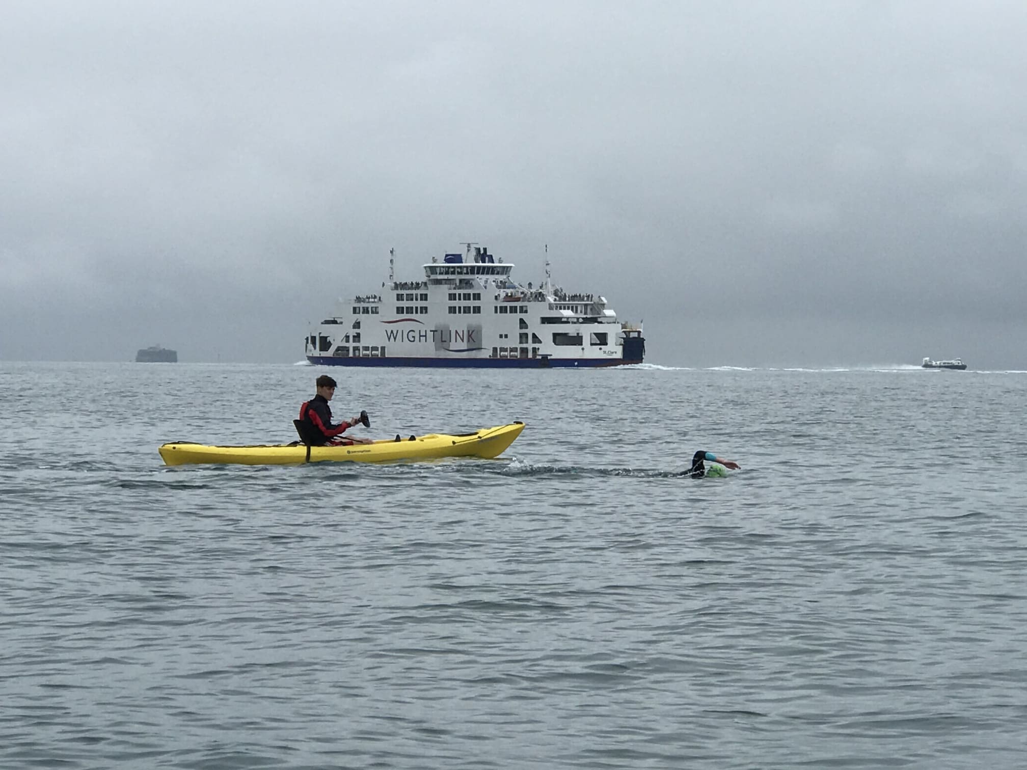 Kayaker and swimmer in front of the Isle of Wight ferry