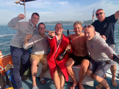 Swimmers celebrating on a relay channel boat