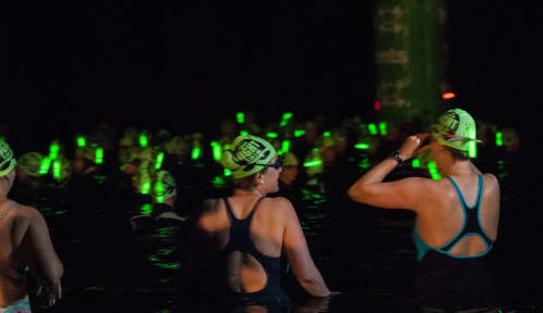 Swimmers getting into the water at night