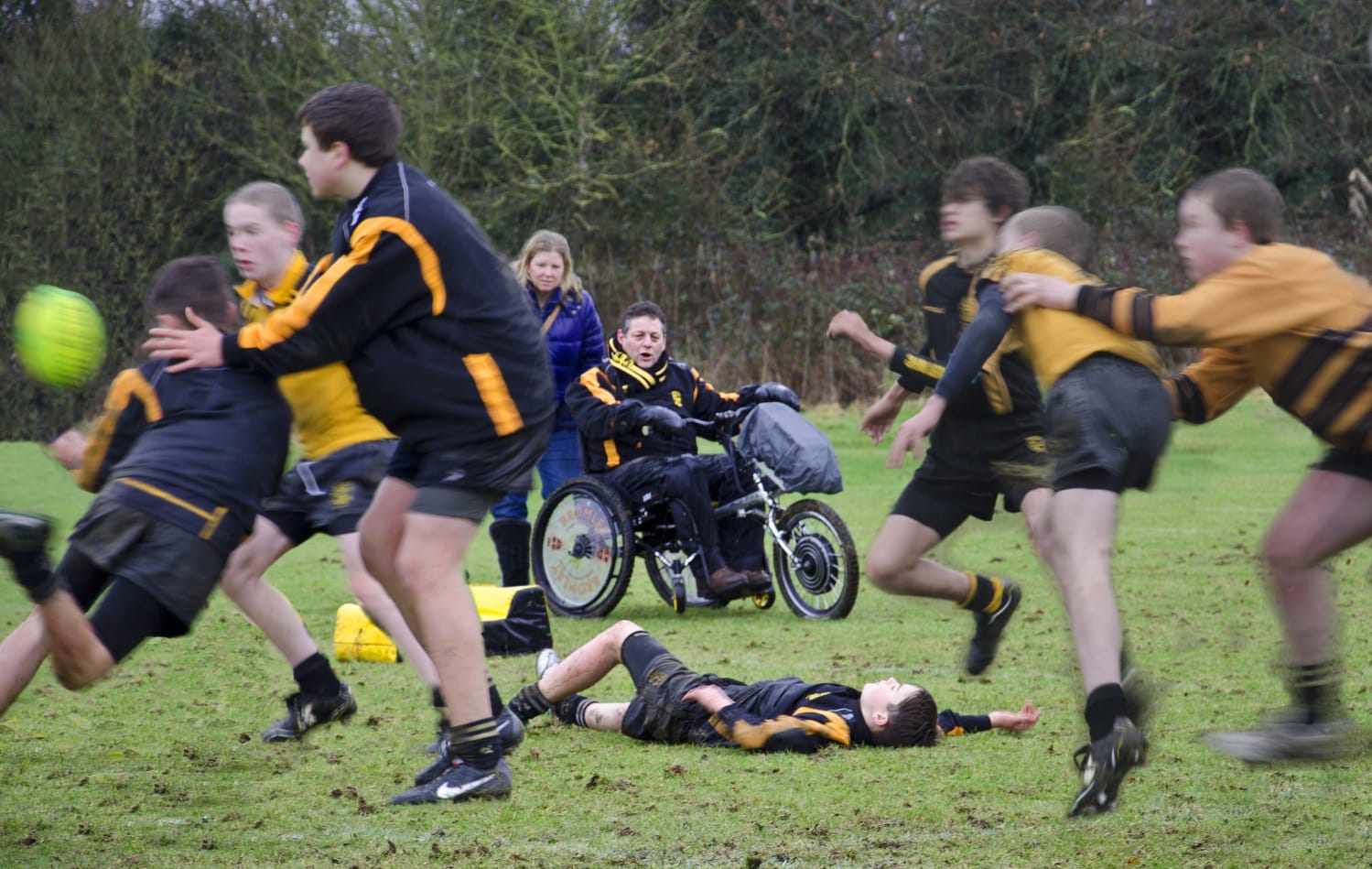 Tim, in his Tri-Ride wheelchair, watching his young son play junior rugby