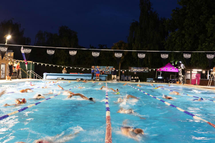 Swimmers in the lido at night