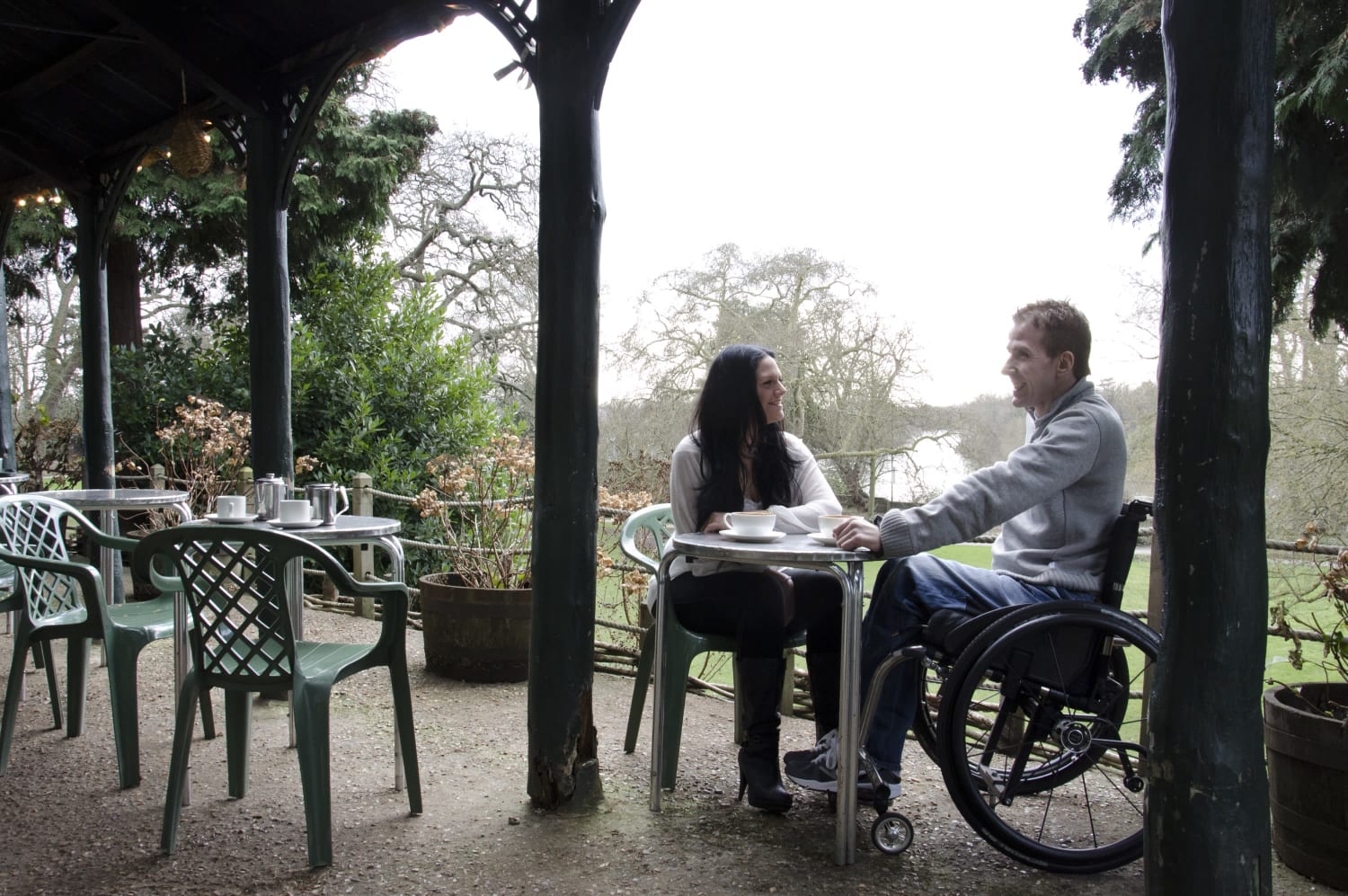 James, in his wheelchair, having tea outside with his girlfriend