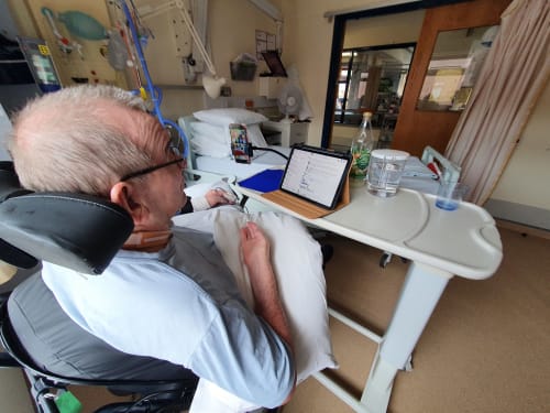 Dennis in hospital using an iPhone and iPad