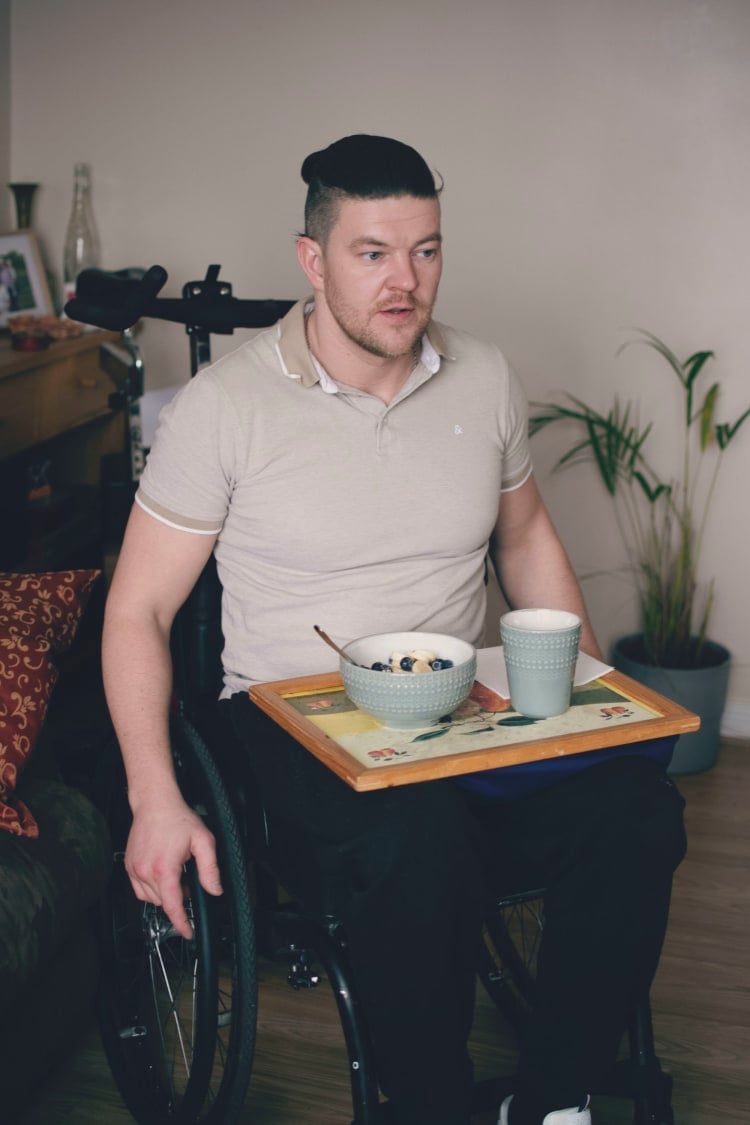 Einers in his wheelchair with tea on a tray