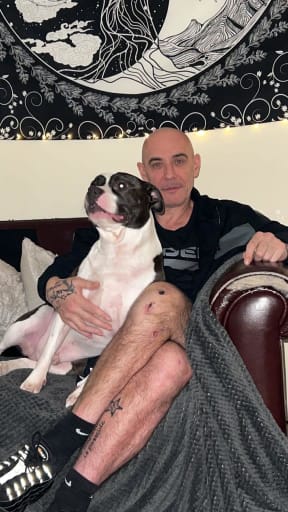 Stephen sitting on a sofa with his dog