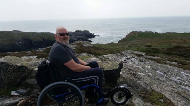 Phil by the sea in his wheelchair